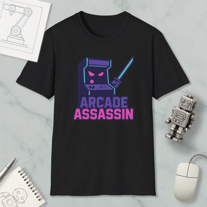 a black t-shirt with a graphic design of a video game arcade character, accompanied by the text "ARCADE ASSASSIN" in pink and purple colors.