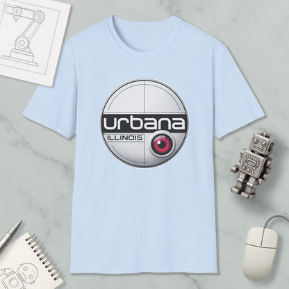 a light blue t-shirt with a circular logo, a computer mouse, a notebook, and a small robot on a marble surface.