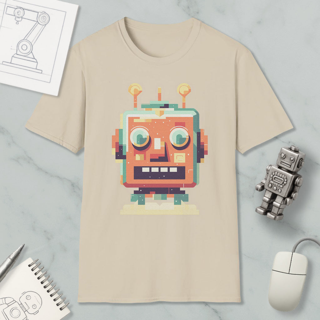 a beige t-shirt with a colorful robot graphic, along with a computer mouse, a notebook, and a small robot figurine.