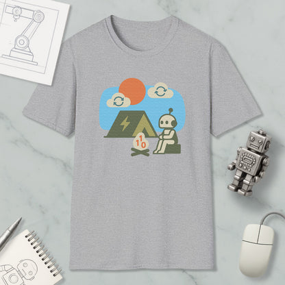 a gray t-shirt with a graphic design depicting a robot sitting by a campfire, with a tent and a small robot figure nearby. The t-shirt is displayed on a marble surface, along with a computer mouse, a notebook, and a small robot figure.