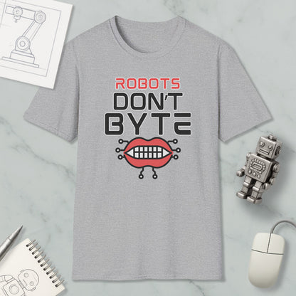 a gray t-shirt with a graphic design that says "ROBOTS DON'T BYTE" and includes a robot mouth with teeth. The t-shirt is placed on a marble surface, surrounded by various objects such as a computer mouse, a notebook, and a pen.