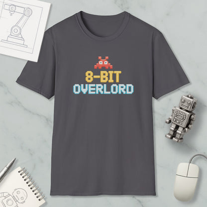 a gray t-shirt with a pixelated robot and text, along with various objects such as a computer mouse, a notebook, and a robot figurine.