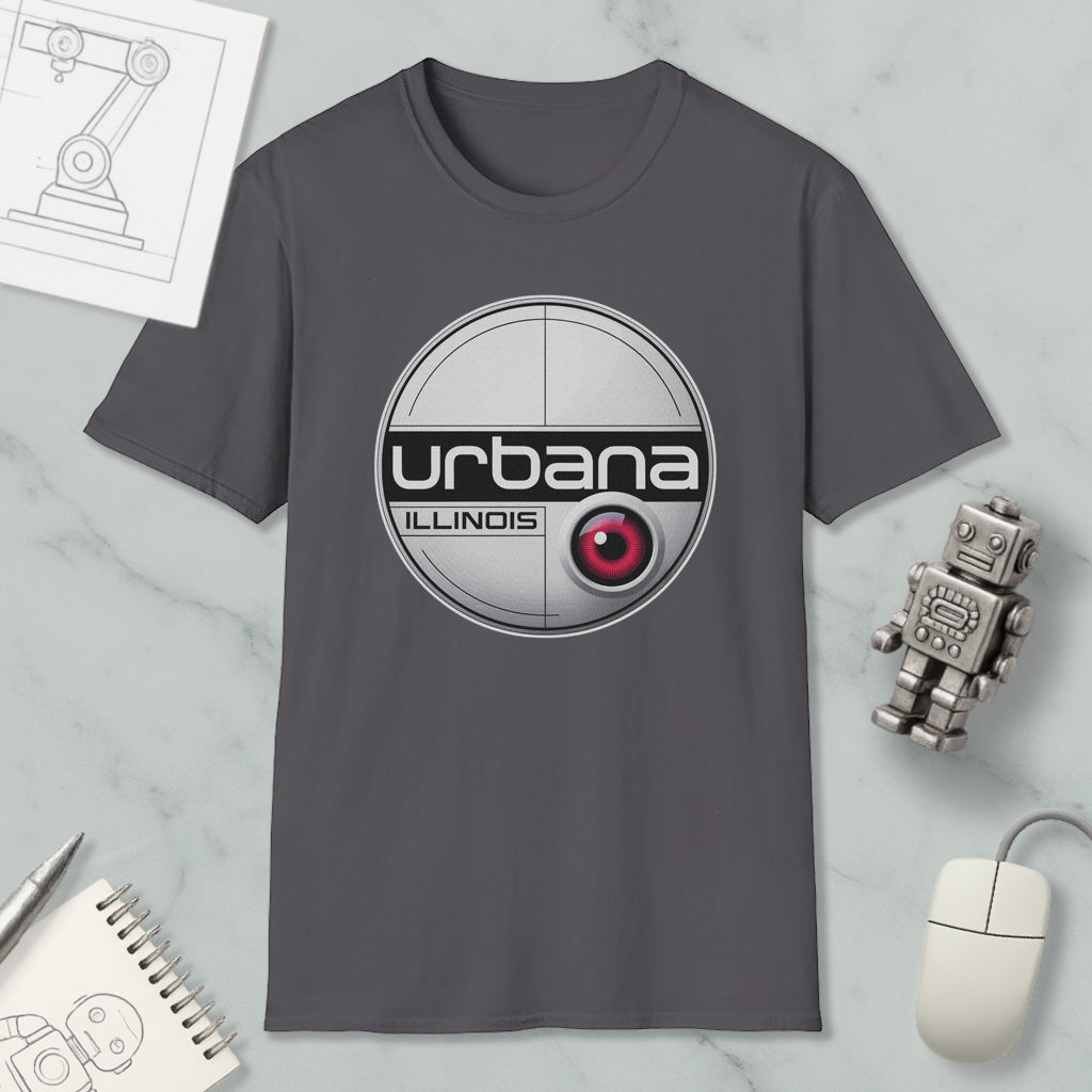 a gray t-shirt with a circular logo, a computer mouse, a notebook, and a small robot on a marble surface.