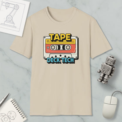 a beige t-shirt with a graphic design of a cassette tape and the text "TAPE Deck Tech" printed on it, along with a small robot and a computer mouse.
