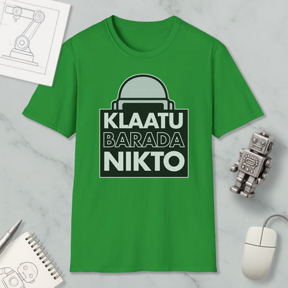 a green t-shirt with a graphic design, a computer mouse, a notebook, and a small robot figurine.