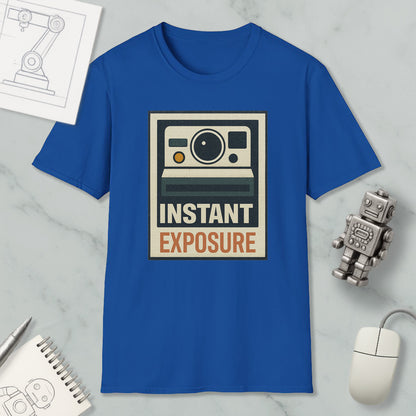 a blue t-shirt with a graphic design, a computer mouse, a notebook, and a small robot on a marble surface.