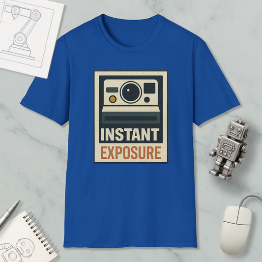 a blue t-shirt with a graphic design, a computer mouse, a notebook, and a small robot on a marble surface.