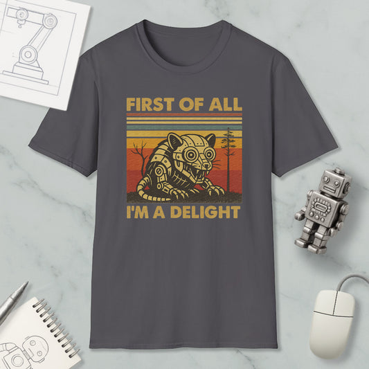 a gray t-shirt with a graphic design depicting a robot or mechanical figure, accompanied by the text "FIRST OF ALL I'M A DELIGHT".