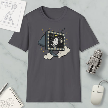 a gray t-shirt with a graphic design depicting a woman's face inside a television set, surrounded by clouds and stars. The t-shirt is placed on a marble surface, with a computer mouse, a notebook, and a robot figurine nearby.