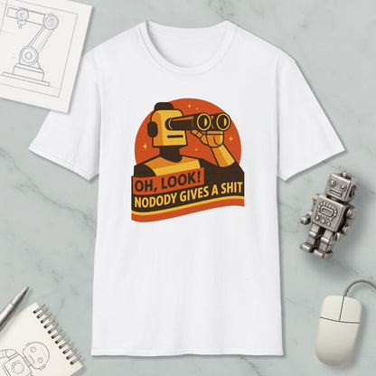 a white t-shirt with a graphic design depicting a robot character looking through binoculars and holding a sign that says "OH, LOOK! NODODY GIVES A SHIT". The t-shirt is displayed on a marble surface, along with a computer mouse, a pen, and a notebook.
