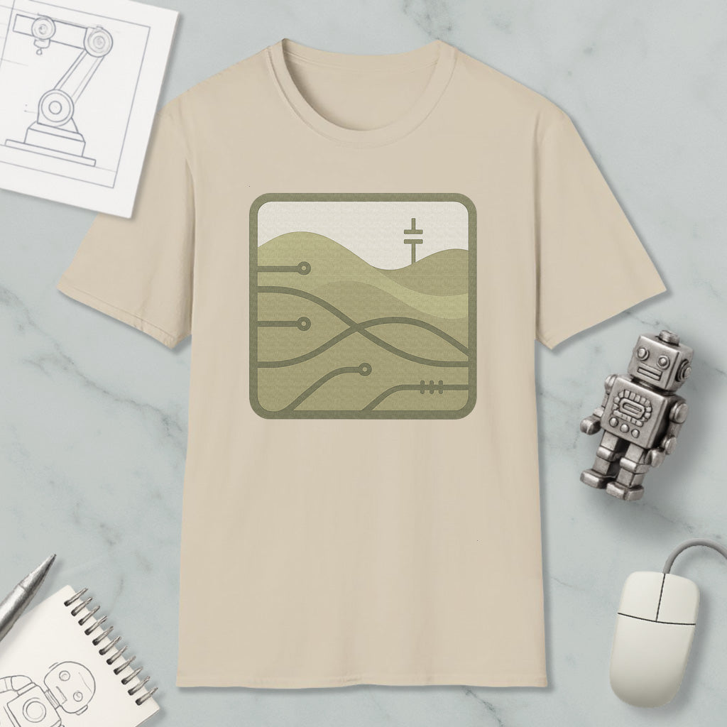 a beige t-shirt with a graphic design, a small robot, a computer mouse, and a notebook on a marble surface.