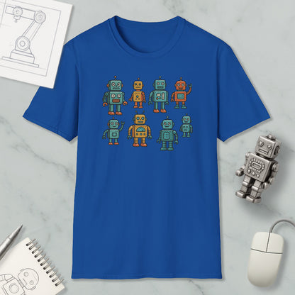 a blue t-shirt with a graphic design of eight colorful robots, including a robot with a human-like face. The t-shirt is placed on a marble surface, and there are various objects such as a computer mouse, a notebook, and a pen nearby.