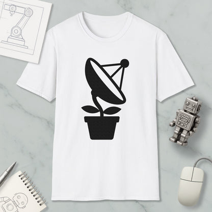 a white t-shirt with a black graphic design of a satellite dish on a plant, along with a computer mouse, a notebook, and a robot figurine.