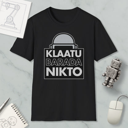 a black t-shirt with a graphic design, a computer mouse, a notebook, and a small robot figurine.
