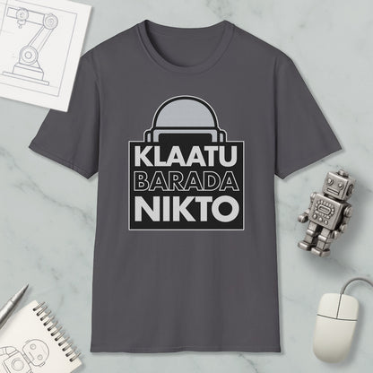a gray t-shirt with a graphic design, a computer mouse, a notebook, and a small robot on a marble surface.
